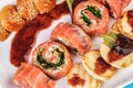 Mediterranean salmon rolls with cheese and greens in chili sauce, served with pancakes and buns Royalty Free Stock Photo