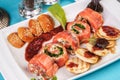 Mediterranean salmon rolls with cheese and greens in chili sauce, served with pancakes and buns Royalty Free Stock Photo