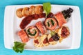 Mediterranean salmon rolls with cheese and greens in chili sauce, served with pancakes and buns Royalty Free Stock Photo