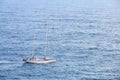 Aerial view of beautiful white sailboat in blue sea at bright sunny summer day.