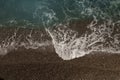 Mediterranean sea waves on a pebble beach on a sunny day Royalty Free Stock Photo