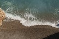 Mediterranean sea waves on a pebble beach on a sunny day Royalty Free Stock Photo