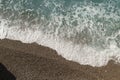 Mediterranean sea waves on a pebble beach on a sunny day Royalty Free Stock Photo