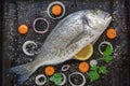 Fresh raw fish of sea bream on black baking sheet