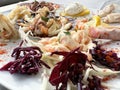 Mediterranean seafood platter with fresh squid, prawns, and cabbage garnish Royalty Free Stock Photo
