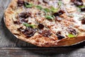 Mediterranean style flatbread pizza, on wood table, close-up, selective focus. Baked flatbread with Italian ingredients.