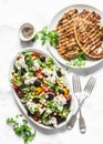 Mediterranean style lunch table - Greek chickpeas salad and pork chops on light background, top view Royalty Free Stock Photo