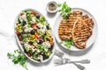 Mediterranean style lunch table - Greek chickpeas salad and pork chops on light background, top view Royalty Free Stock Photo