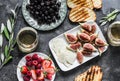 Mediterranean style snack appetizers - dried olives, figs, cheese, grilled bread, strawberries, raspberries and white wine on a Royalty Free Stock Photo