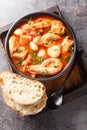 Mediterranean thick stew of seafood and fish with tomatoes close-up in a bowl. Vertical top view