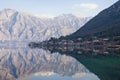 Mediterranean village of Stoliv with mountains and reflection in water on a winter day. Kotor Bay of Adriatic Sea, Montenegro Royalty Free Stock Photo