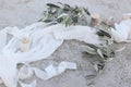 Mediterranean wedding still life. Olive tree branches, fruit with silk ribbons and white muslin table runner, cloth or