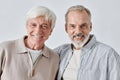 Two Beaming Senior Men Looking at Camera