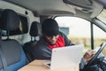 Medium closeup shot POV of passenger seat. Adult focused African-American man seating behind the wheel of white delivery Royalty Free Stock Photo