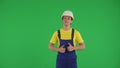 Medium green screen isolated chroma key shot of a young construction worker giving a thumbs-up at the camera. Royalty Free Stock Photo