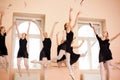 Medium group of teenage ballerinas in black dresses celebrating end of the school year