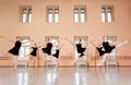 Medium group of teenage girls practicing classical ballet in a large dancing studio