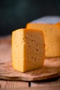 Medium hard cheese gouda edam on wooden board on sunlight table traditional table texture Royalty Free Stock Photo