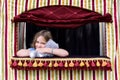 Little girl squeezing stuffed animal puppet in small puppet theater