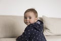 Medium horizontal shot of adorable fair toddler girl with dreamy expression turning back