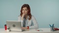 Medium isolated shot of a dissatisfied and confused young woman sitting at the desk with laptop and working supplies Royalty Free Stock Photo