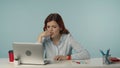 Medium isolated shot of a stressed and nervous young woman looking at the screen of her laptop, anxiously waiting for Royalty Free Stock Photo