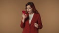 Medium isolated shot of a woman holding a smartphone in her hand reacting to the negative responce, message, news with