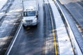 Medium Power rig semi Truck with roof spoiler running on the winter snowy road with divided lines