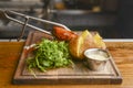 Medium rare grilled Beef steak with roasted potato wedges and green salad on cutting board on wooden background. Royalty Free Stock Photo