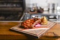 Medium rare grilled Beef steak with roasted potato wedges and green salad on cutting board on wooden background. Royalty Free Stock Photo