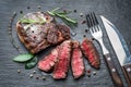 Medium rare Ribeye steak with herbs on graphite board Royalty Free Stock Photo