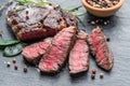 Medium rare Ribeye steak with herbs on graphite board Royalty Free Stock Photo