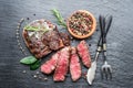 Medium rare Ribeye steak with herbs on graphite board Royalty Free Stock Photo