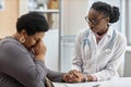 Female General Practitioner Consoling Crying Patient