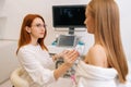 Medium shot of beautiful young woman getting breast examination during appointment at hospital. Female doctor using Royalty Free Stock Photo