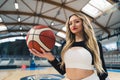 Medium shot of a blond cheerleader with a basketball in her palm. Sport concept. Royalty Free Stock Photo