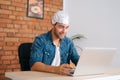 Medium shot of crazy male conspiracy theorist wearing aluminum foil protect brain watching shocked online video content