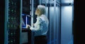 Female technician works on a tablet in a data center Royalty Free Stock Photo