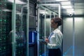 Female technician works on a tablet in a data center Royalty Free Stock Photo