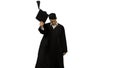 Male graduate walking in the frame, throwing his mortarboard and doing a handspring on white background.