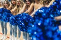 Medium shot of a group of cheerleaders with their arm stretched. Blurred foreground. Sport concept.