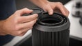 Medium shot of hands inspecting and cleaning the filter of a bagless vacuum cleaner ensuring optimal suction performance Royalty Free Stock Photo