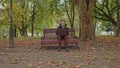 Medium shot of handsome young man working on laptop computer sitting outdoors in park. Male looking away thoughtfully Royalty Free Stock Photo