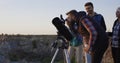 Friends stargazing together using a professional telescope