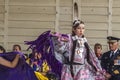 A medium shot of a indigenous teen talent showcase, wearing a purple traditional cloths