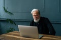 Medium shot of mature adult bearded man watching business training, online webinar on laptop remote working or social Royalty Free Stock Photo