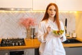 Medium shot portrait of attractive young redhead woman eating fresh vegetarian salad enjoying fresh tasty vegetables. Royalty Free Stock Photo