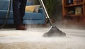 Medium shot of a professional using hot water extraction on a carpet lifting deepseated dirt and grime efficiently for a Royalty Free Stock Photo