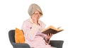 Retired woman reading a book sitting on a chair on white backgro Royalty Free Stock Photo