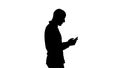 Silhouette Young man walking and using a phone. Royalty Free Stock Photo